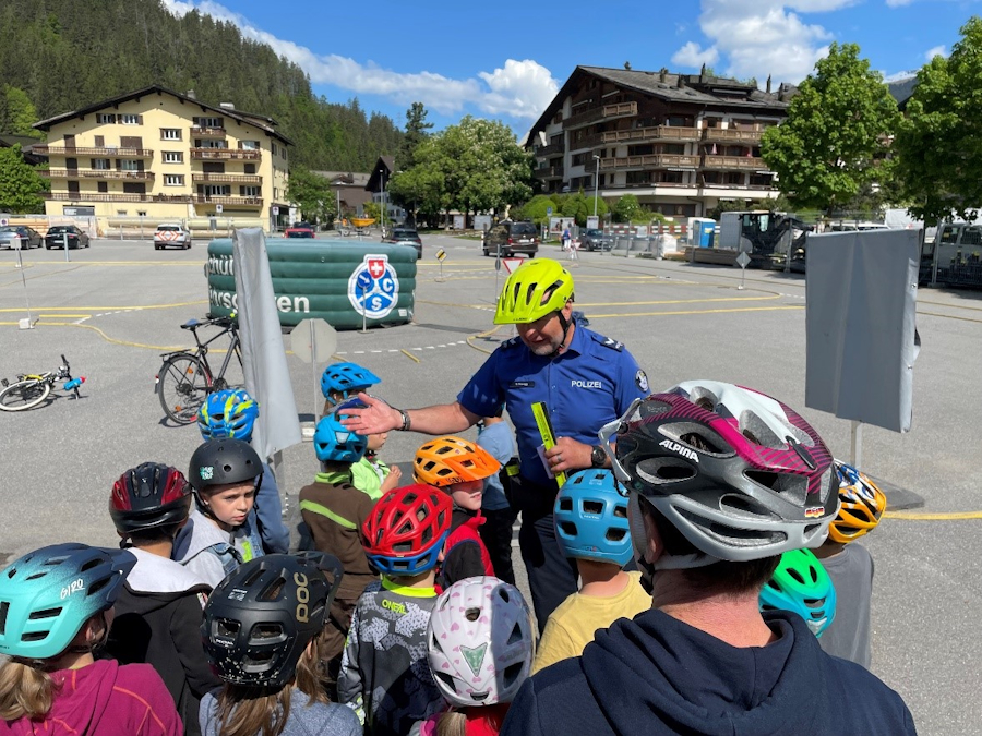 Ein Verkehrsinstruktor erklärt den Kindern im Schülerverkehrsgarten das richtige Verhalten beim Fahrradfahren