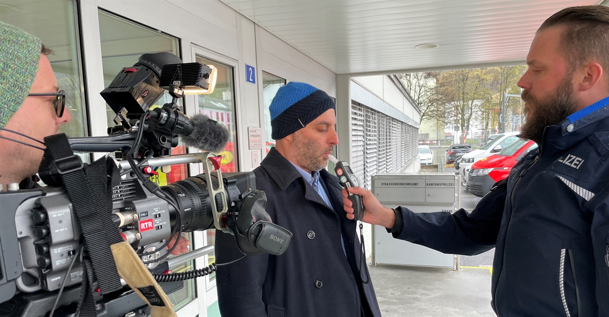 Journalist bläst in Röhrchen für Atemlufttest